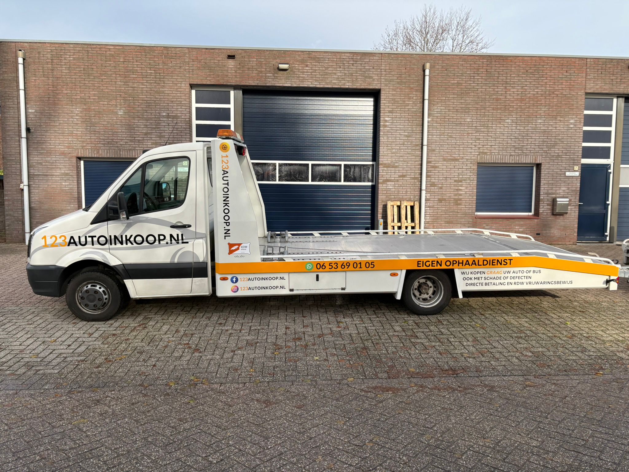 Ophaalwagen van 123AutoInkoop.nl voor het bedrijfspand